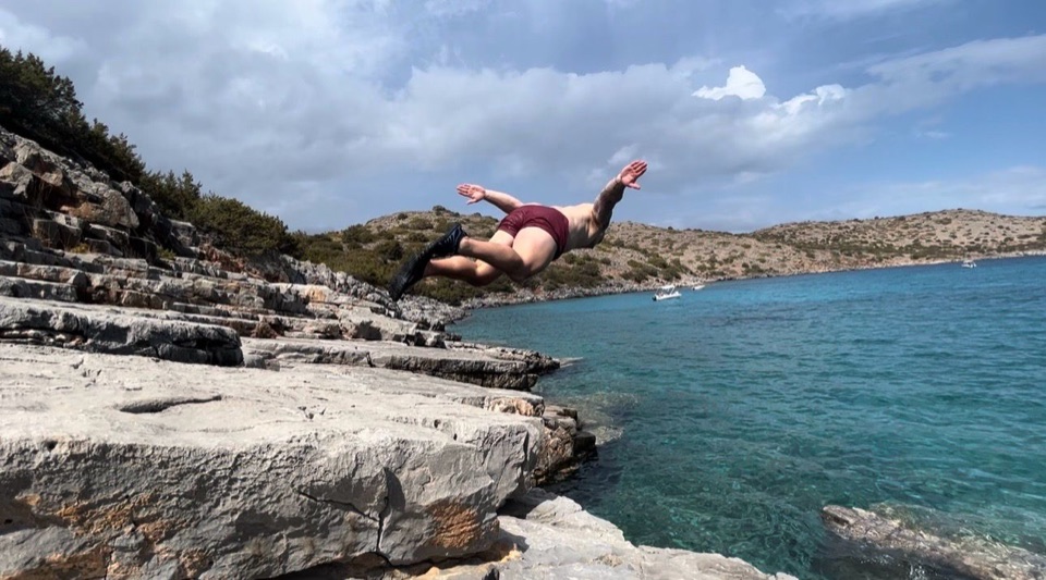Craig diving from rocks into clear blue water