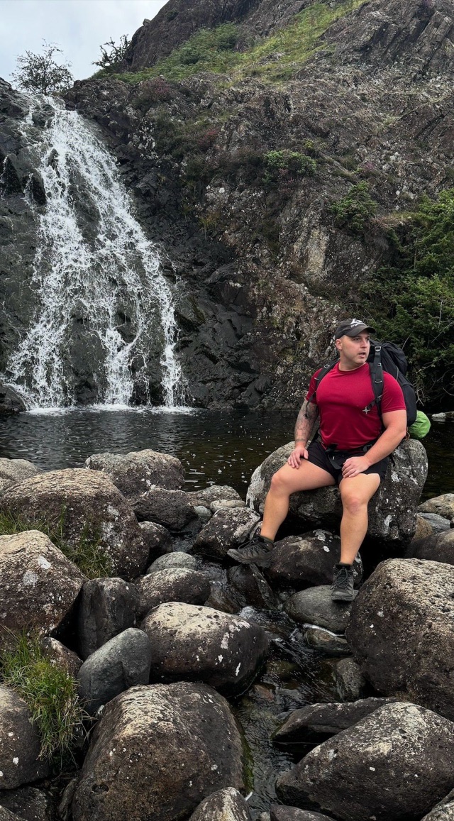 Craig sitting beside a waterfall after hiking