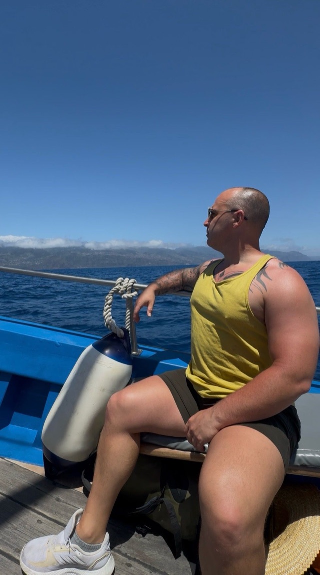 Craig sitting on a boat looking across the sea