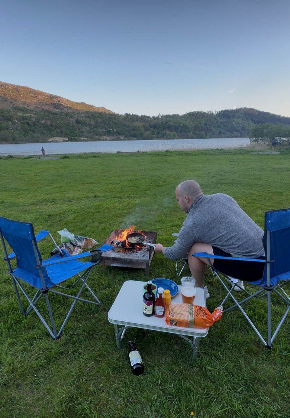 Craig Silkens cooking outdoors by a lakeside campfire
